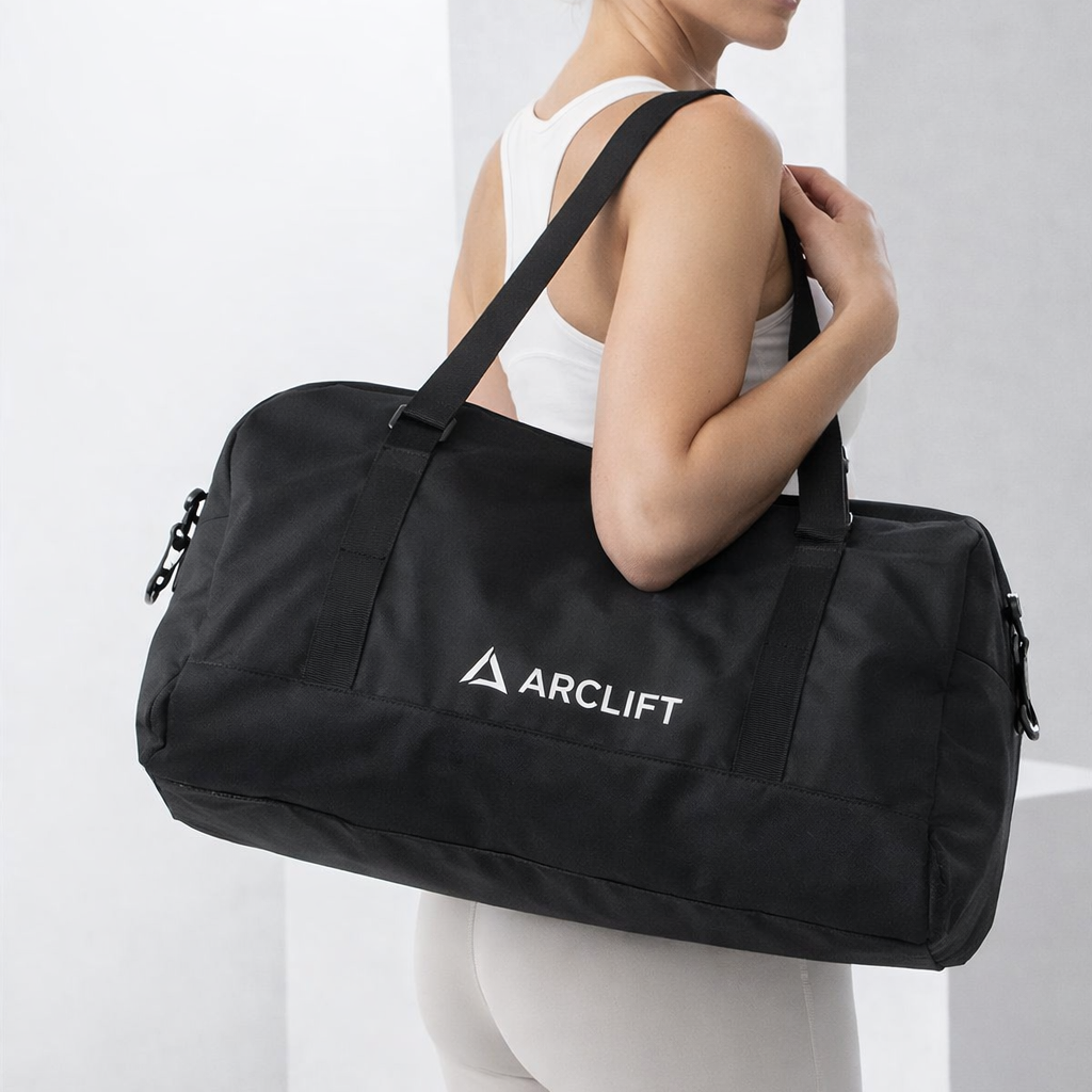 Woman holding a black duffel bag with Arclift logo against a white background